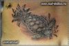 Черно-белая женская татуировка на пояснице. Морская черепаха в лотосах.